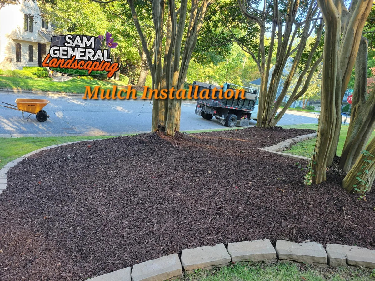 Fresh mulch installation around trees and a curved stone garden border — landscaping services serving Cary NC