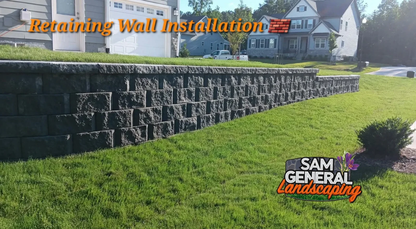 Completed gray concrete block retaining wall beside a residential lawn — retaining wall services serving Cary NC